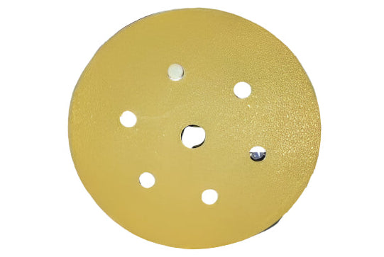 Gold sanding disc with multiple holes on a white background